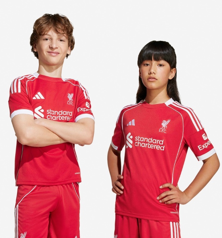 Kinderen dragen Liverpool thuistenue 2025/26 van Adidas met rood shirt en sportieve pasvorm